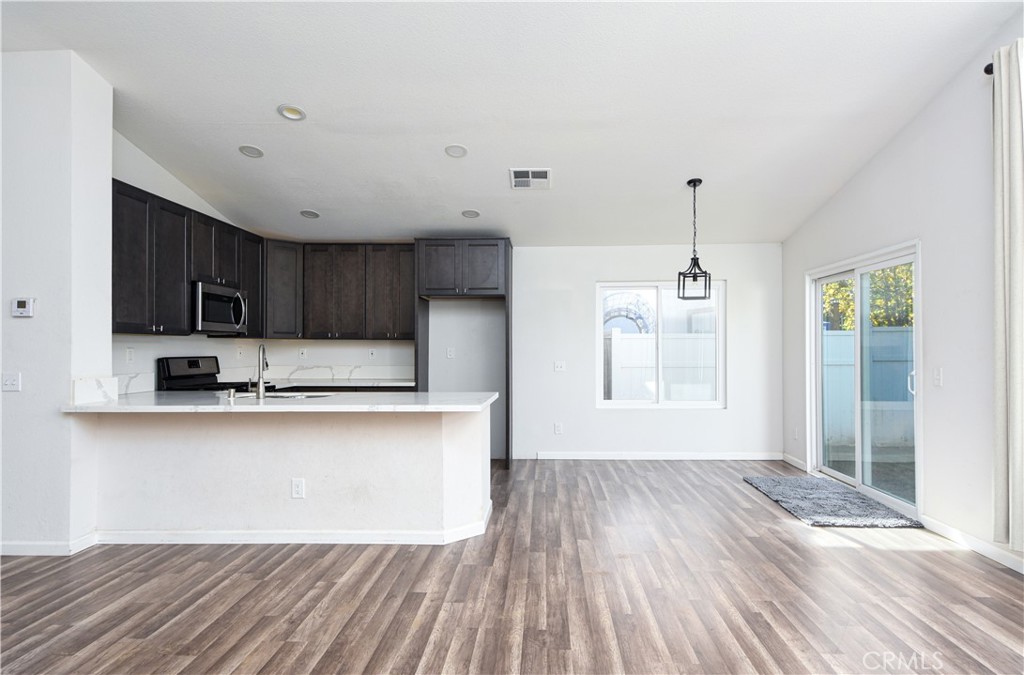 3714 Avondale Street Perris, CA 92571 - Photo 4 of 19 a kitchen with stainless steel appliances granite countertop a refrigerator a sink dishwasher a stove and white countertops with wooden floor