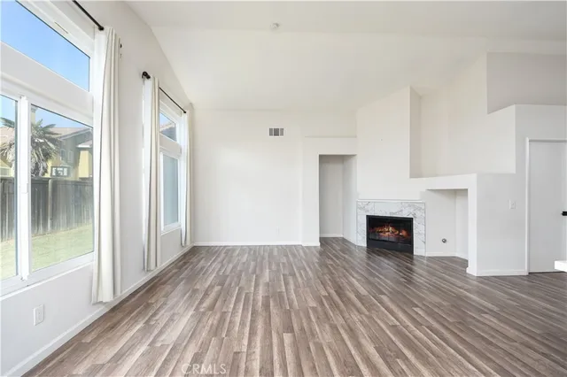 a view of empty room with wooden floor and fireplace