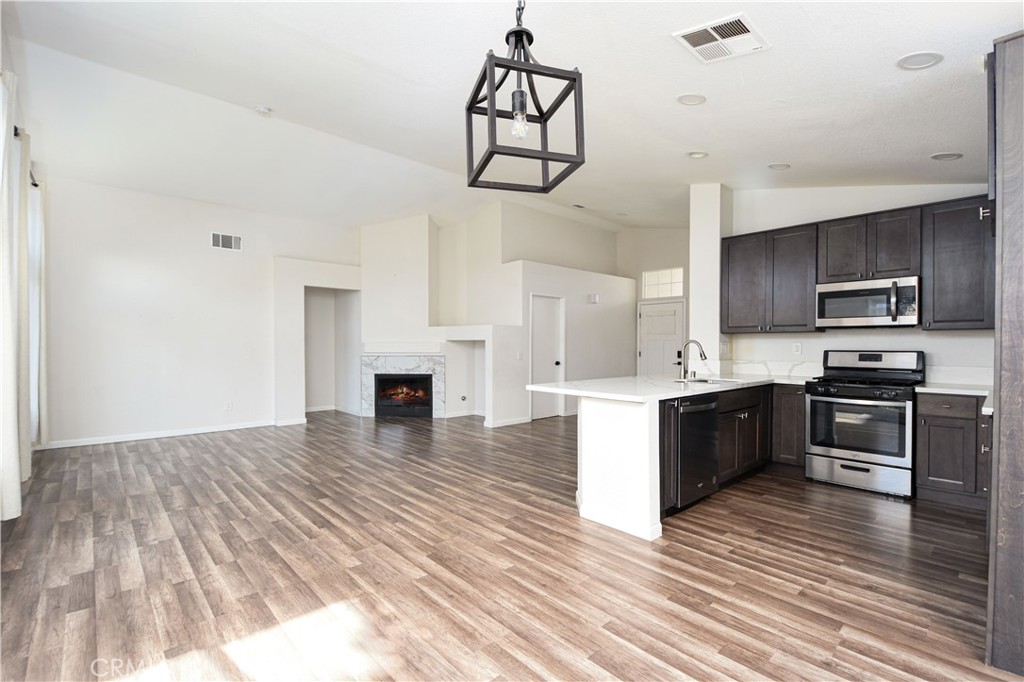 3714 Avondale Street Perris, CA 92571 - Photo 10 of 19 a kitchen with stainless steel appliances granite countertop a refrigerator a stove oven a sink dishwasher and white cabinets with wooden floor