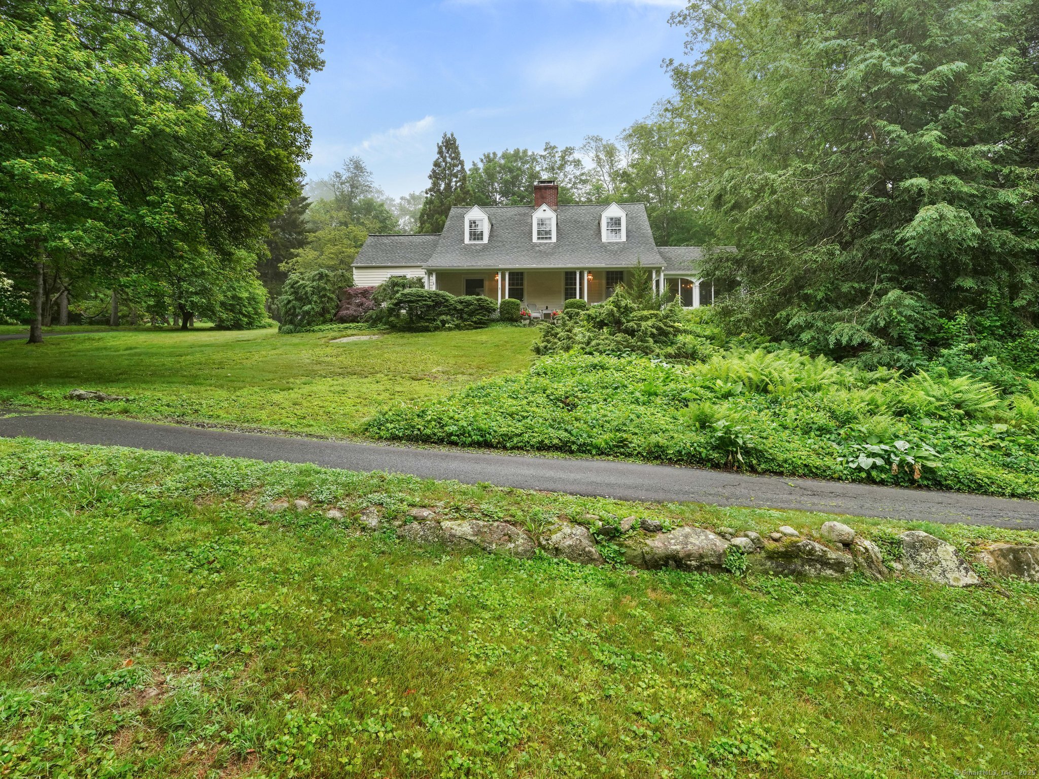 a view of a big house with a big yard and large trees
