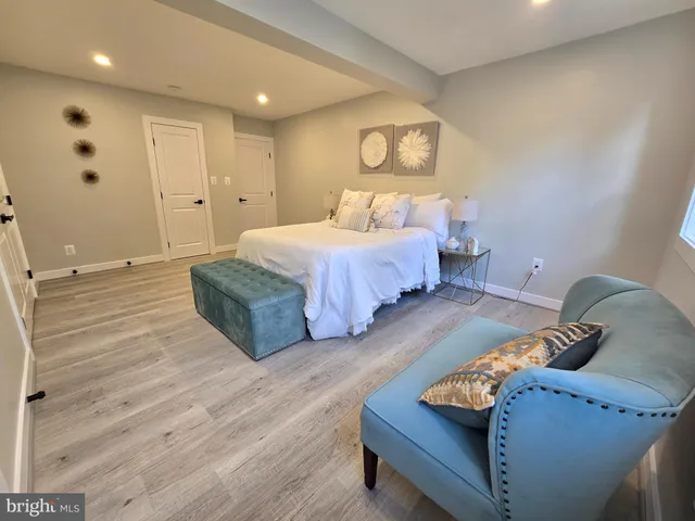 a spacious bedroom with a bed and wooden floor