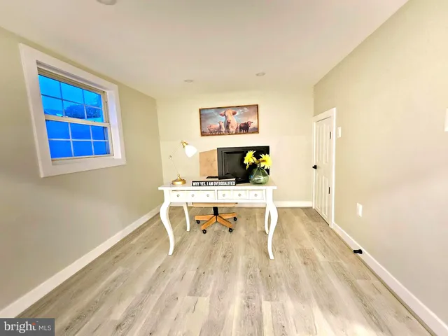 a view of a room with a wooden floor and furniture