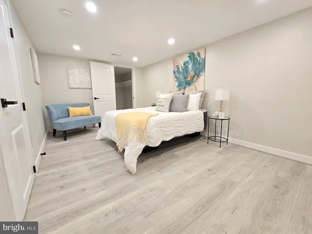 a spacious bedroom with a bed a couch and a potted plant on table