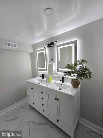 a bathroom with a double vanity sink and mirror