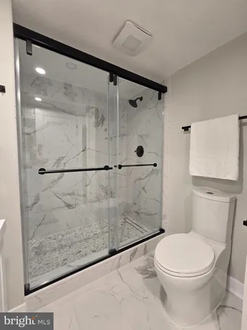 a white toilet sitting next to a bath tub shower