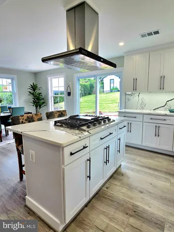 a kitchen with granite countertop a sink cabinets stainless steel appliances and a large window