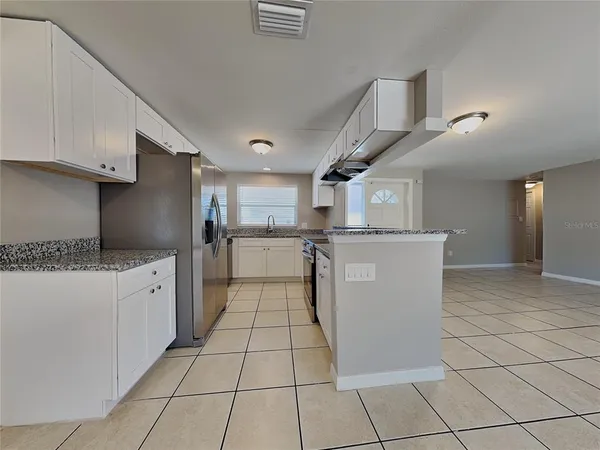 a kitchen with stainless steel appliances granite countertop a refrigerator and a stove