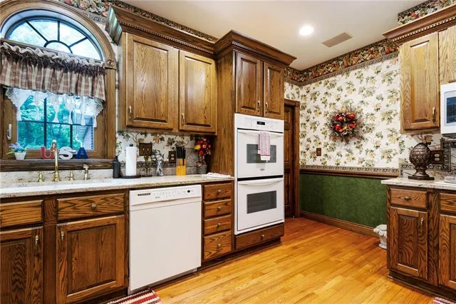 a kitchen with stainless steel appliances granite countertop a stove a sink and a microwave