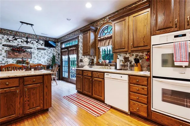 a kitchen with stainless steel appliances granite countertop a stove a sink and a microwave
