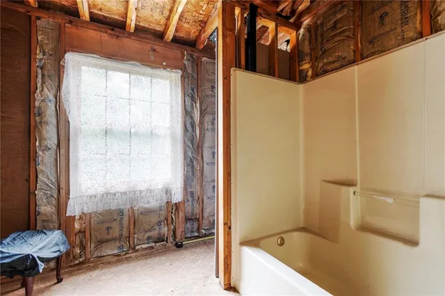 a bathroom with a tub a sink and a window