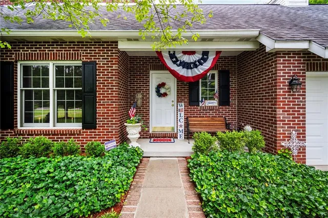 a front view of a house with a garden and plants