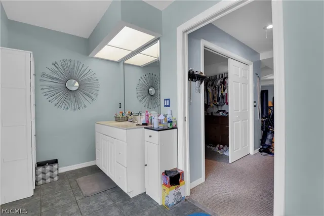 a room with a mirror and cabinets