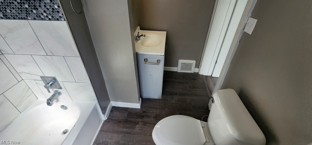 1514 Clermont Road Cleveland, OH 44110 - Photo 8 of 16 Full bathroom with dark wood-style floors, vanity, and shower / washtub combination