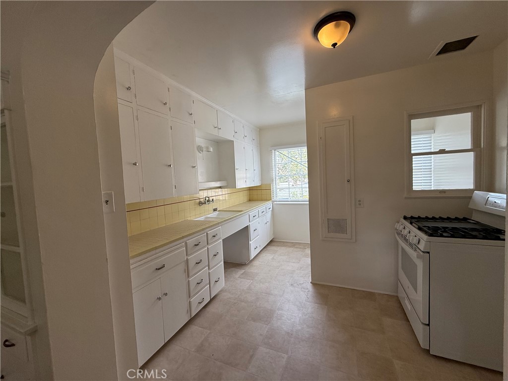 4121 4th Street Riverside, CA 92501 - Photo 23 of 25 a kitchen with granite countertop a sink stove and cabinets