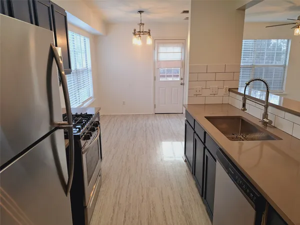 a kitchen with sink a refrigerator and window