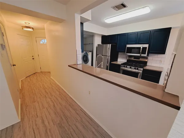 a kitchen with stainless steel appliances a refrigerator and a stove top oven