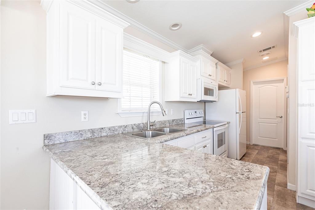 1329 Trout Punta Gorda, FL 33950 - Photo 11 of 38 a kitchen with stainless steel appliances granite countertop a sink stove and cabinets