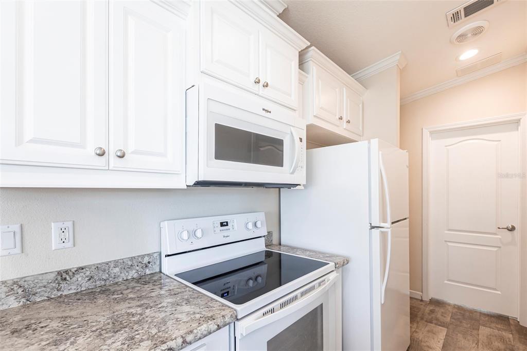 1329 Trout Punta Gorda, FL 33950 - Photo 13 of 38 a kitchen with white cabinets and white appliances