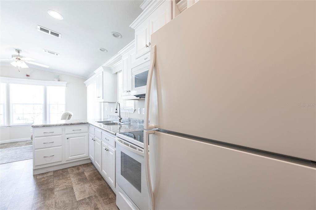 1329 Trout Punta Gorda, FL 33950 - Photo 9 of 38 a kitchen with granite countertop white cabinets and white appliances