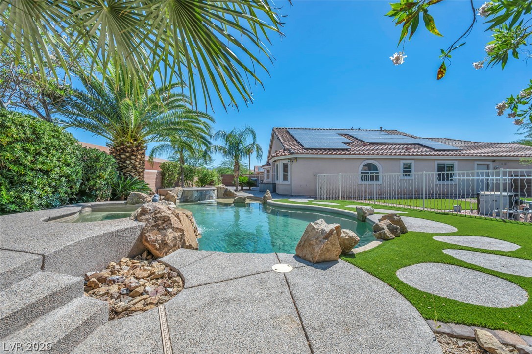 6405 North Raptor Court North Las Vegas, NV 89084 - Photo 47 of 66 An inviting backyard oasis offers a rock-scaped pool, spa, and sun-soaked turf.