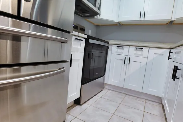 a kitchen with appliances cabinets and a stove top oven
