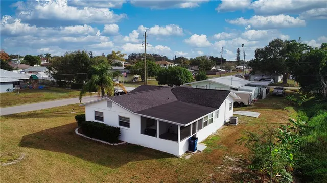 a view of a house with pool and a yard