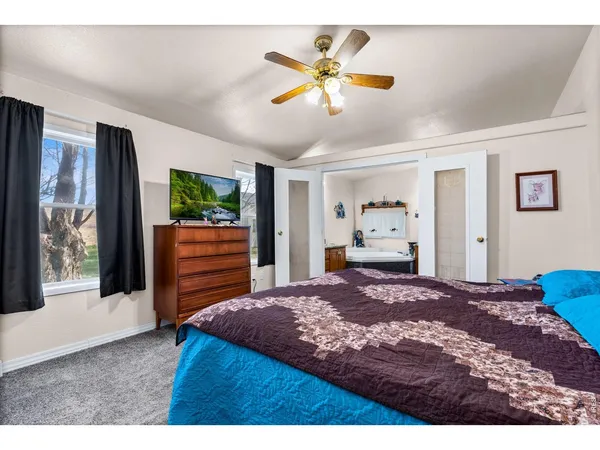 a bedroom with a large bed and a flat screen tv