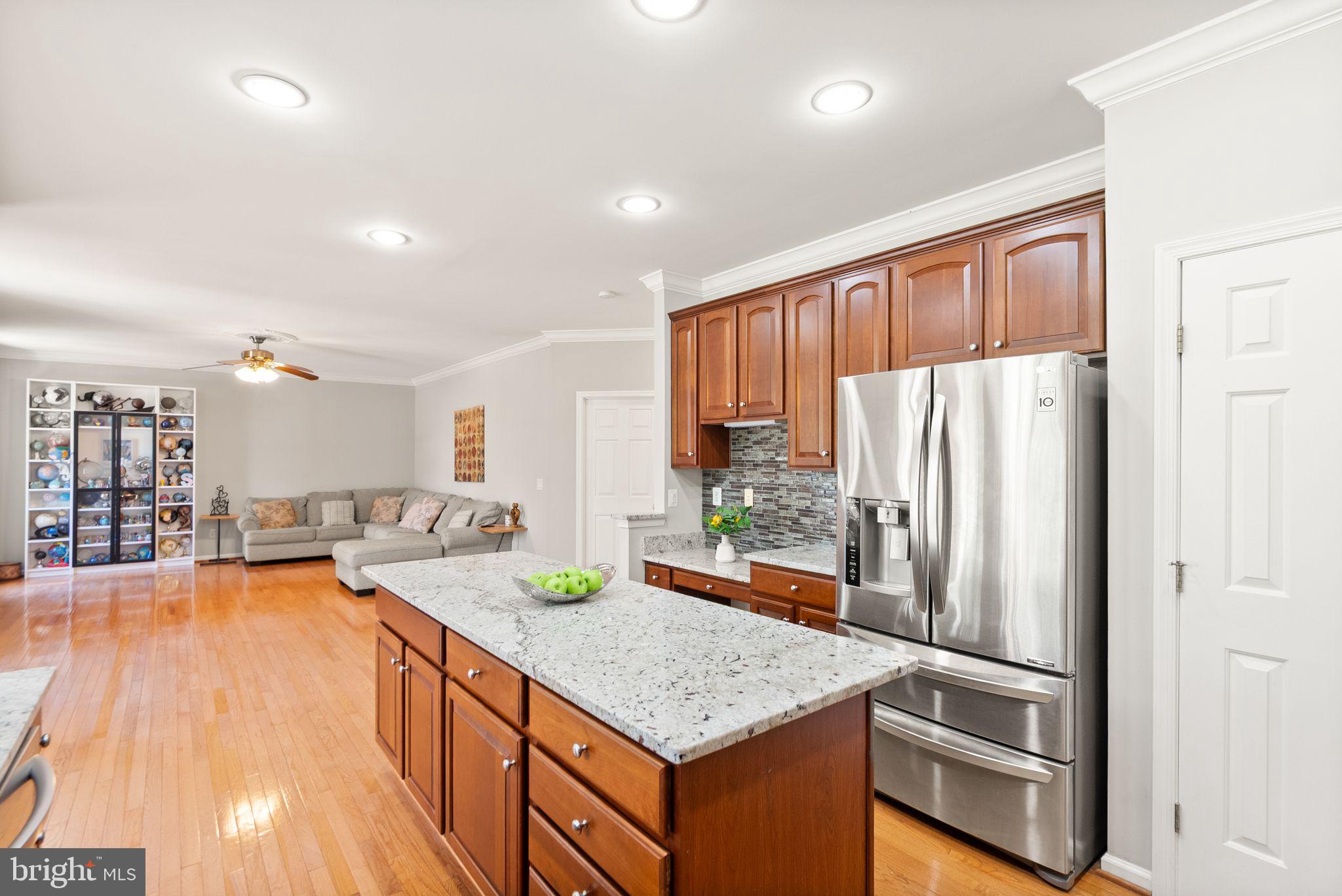 6901 Bitterroot Court Gainesville, VA 20155 - Photo 18 of 98 a kitchen with stainless steel appliances granite countertop a refrigerator a sink and a stove with wooden floor