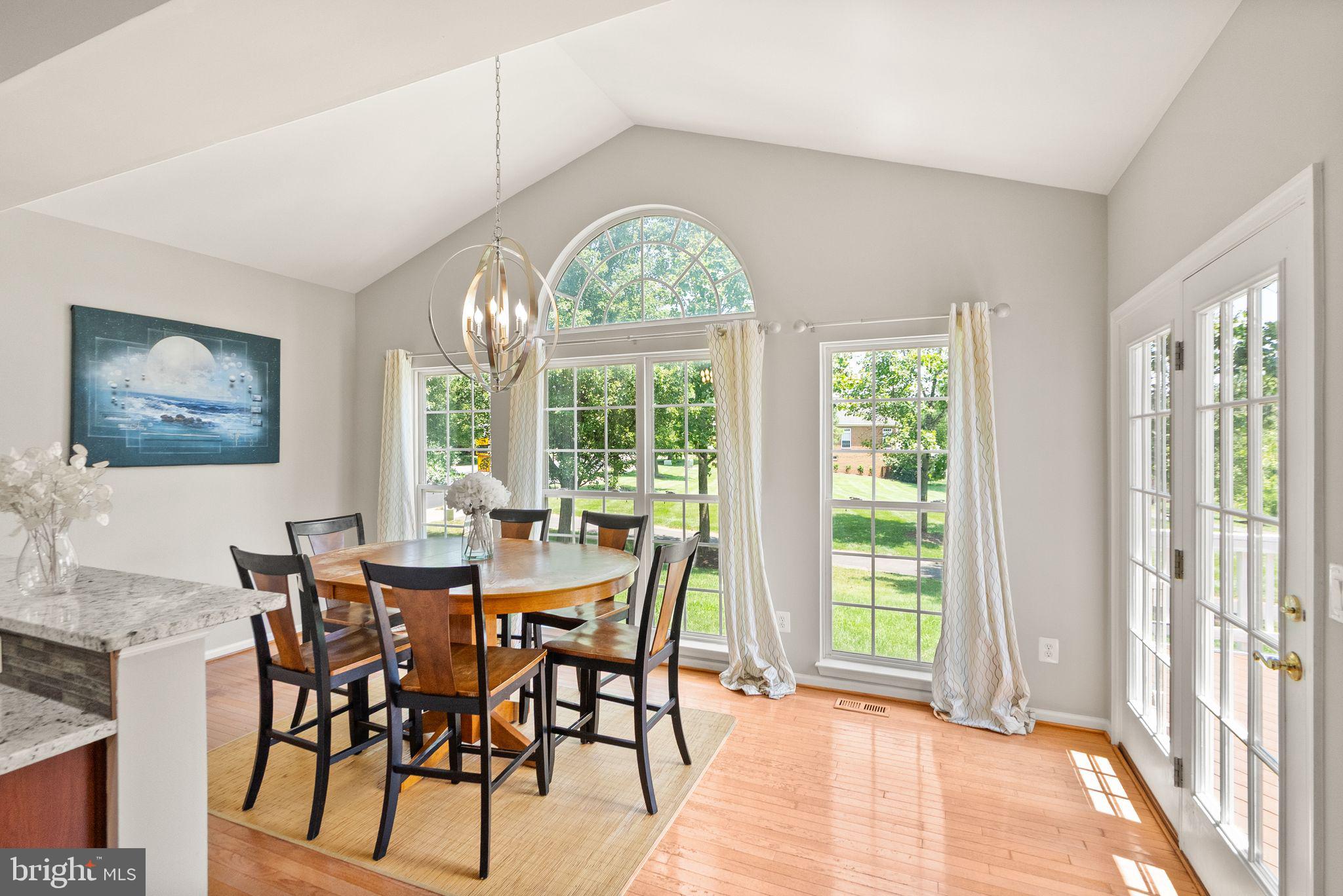 6901 Bitterroot Court Gainesville, VA 20155 - Photo 21 of 98 a view of a dining room with furniture large windows and wooden floor