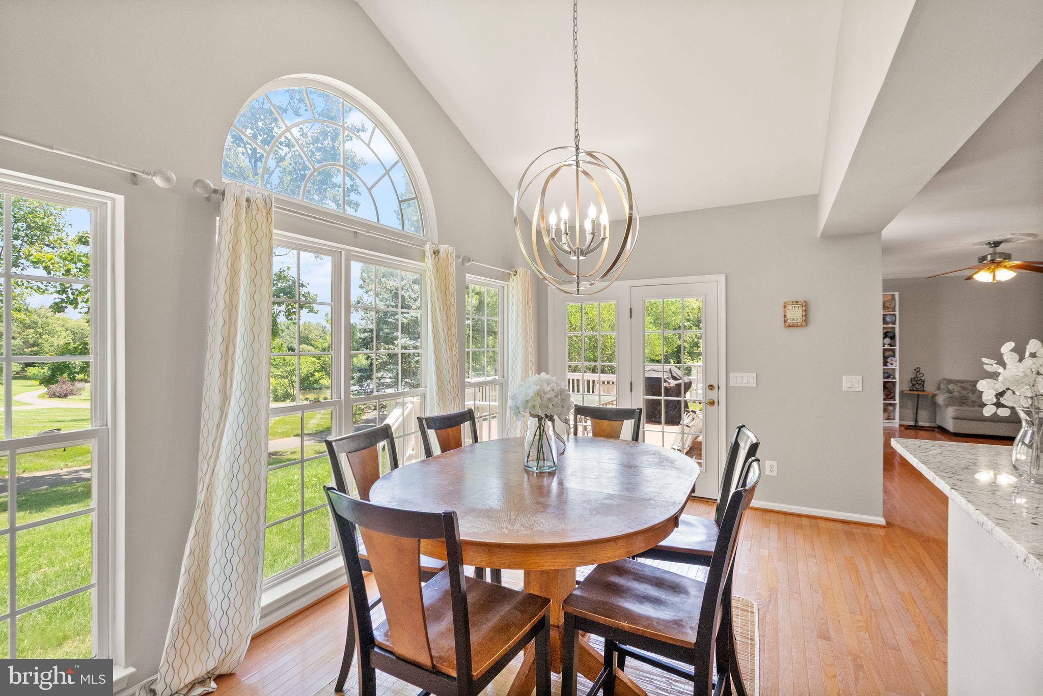 6901 Bitterroot Court Gainesville, VA 20155 - Photo 22 of 98 a view of a dining room with furniture a chandelier and wooden floor