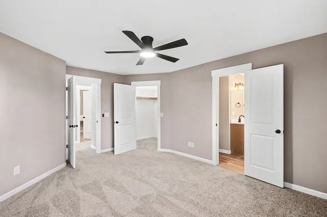 a view of a livingroom with a ceiling fan & entryway