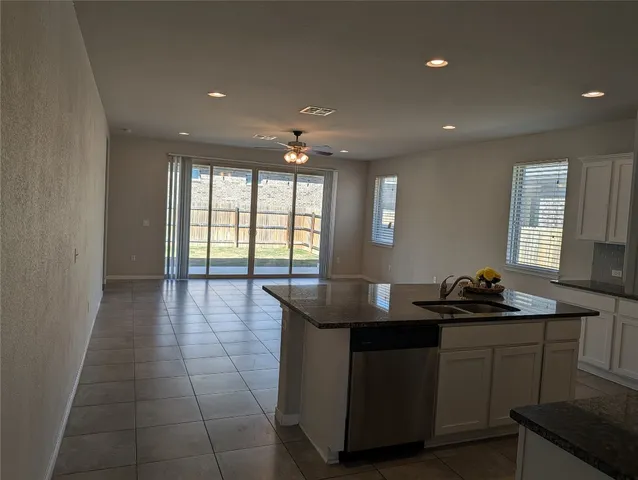 a large kitchen with stainless steel appliances a refrigerator a stove a sink dishwasher and a stove with wooden floor