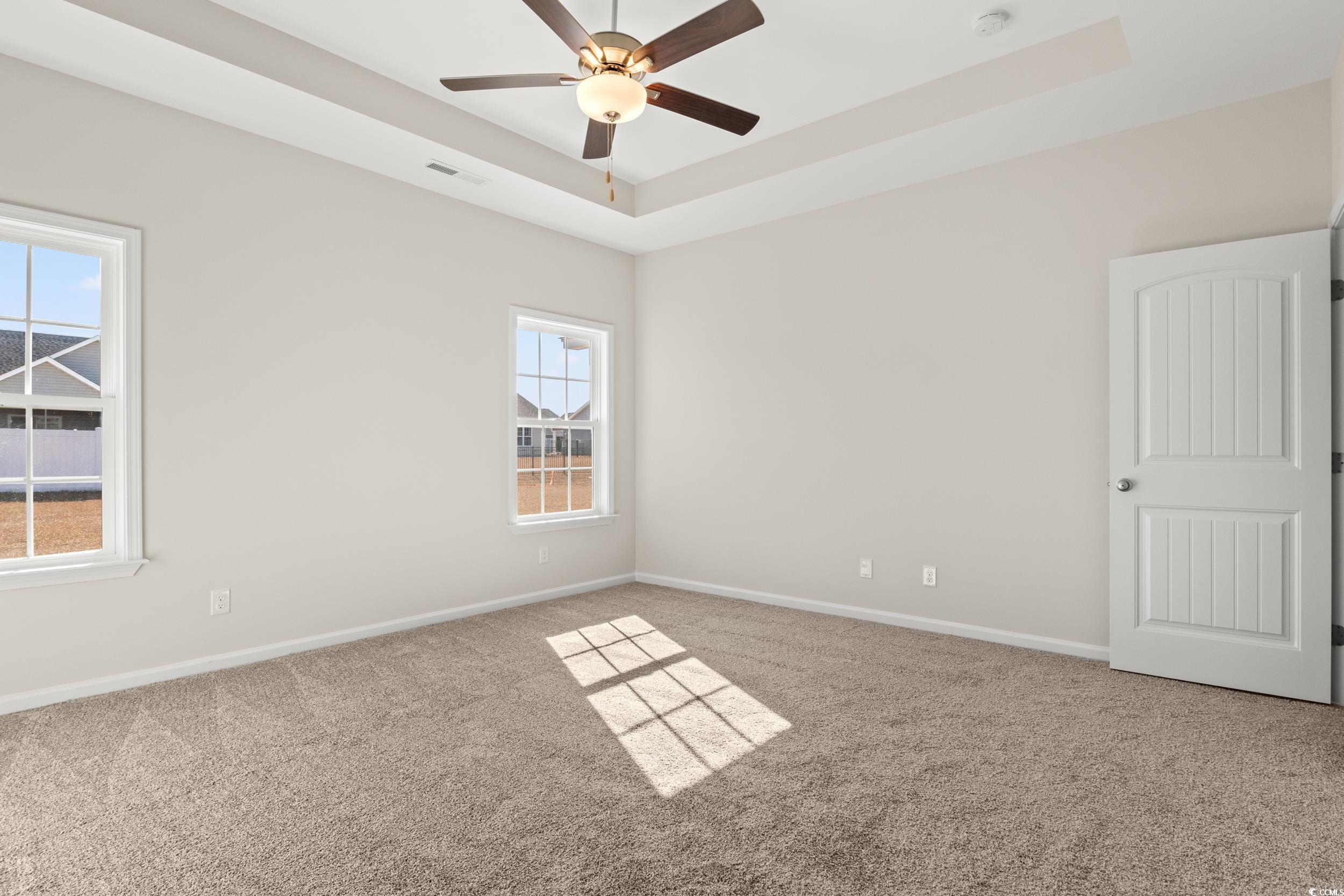 609 Bay Street Aynor, SC 29544 - Photo 13 of 17 Unfurnished room featuring a tray ceiling, carpet floors, and a ceiling fan