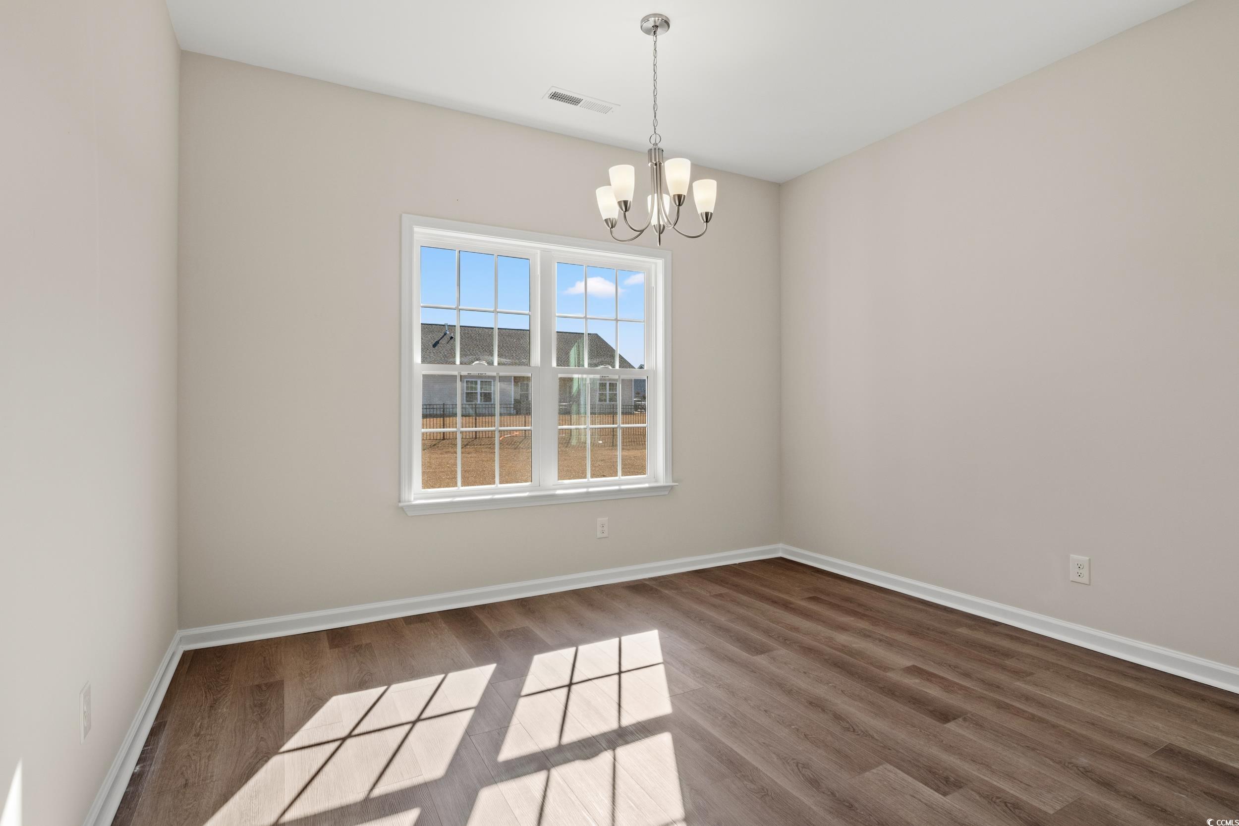 609 Bay Street Aynor, SC 29544 - Photo 16 of 17 Unfurnished dining area featuring wood finished floors and a chandelier