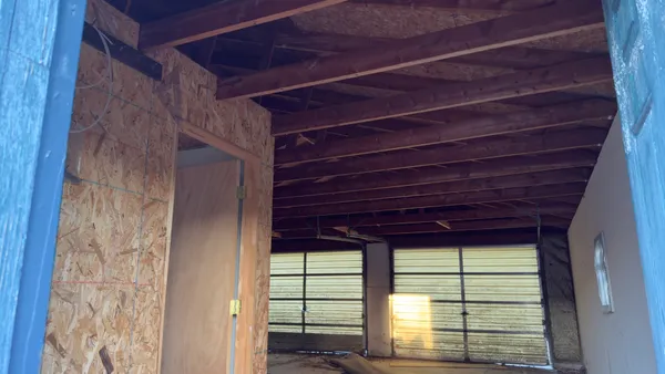 a view of a room that has a large window and wooden floor