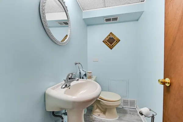 a bathroom with a toilet sink and mirror
