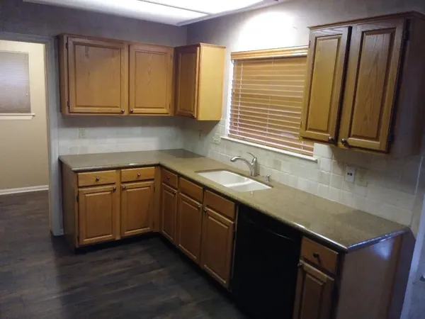a kitchen with a sink cabinets and wooden floor