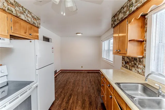 a kitchen with a sink a refrigerator and cabinets