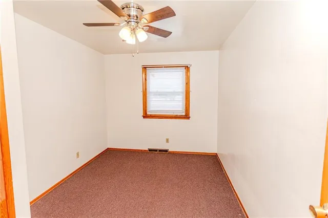 a view of an empty room with a ceiling fan