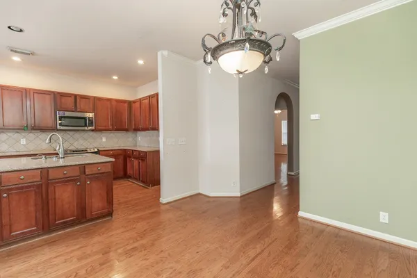 a open kitchen with kitchen island a sink appliances and cabinets