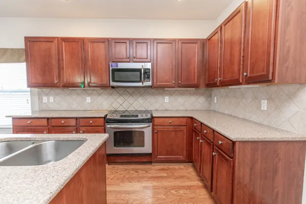 a kitchen with stainless steel appliances granite countertop a sink stove and microwave
