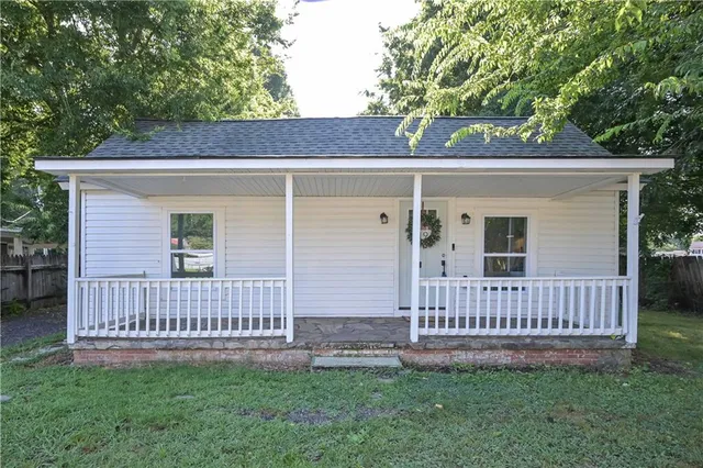 a view of a house with a small yard and wooden fence