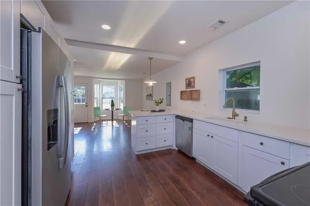 a view of a kitchen with sink hardwood floor and a large window