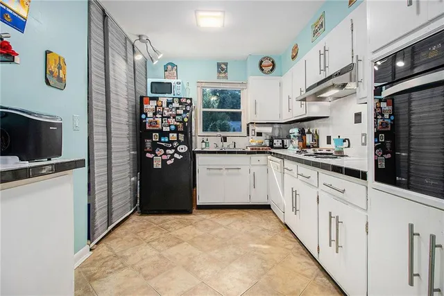 a kitchen with a sink a stove and cabinets