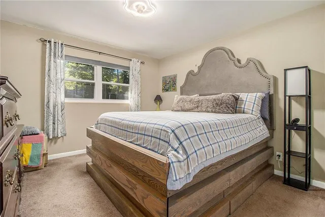 a bed sitting in a bedroom next to a window