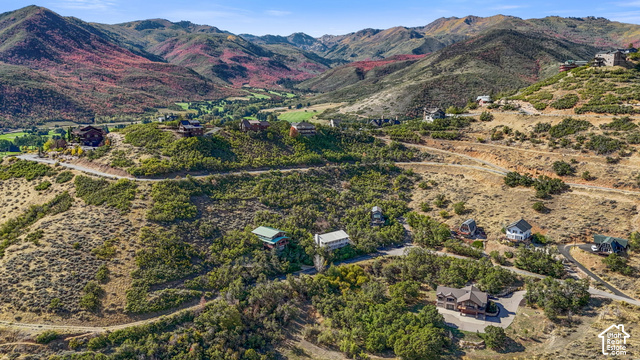 Expansive mountainous terrain featuring scattered residential properties, paved roadways, and varied natural vegetation