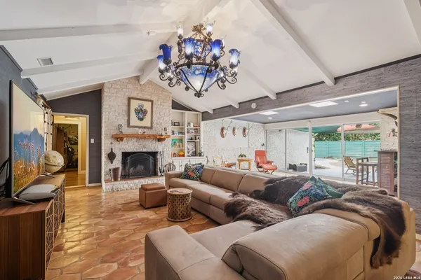 a living room with furniture a fireplace and a large window