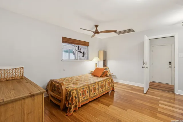 a bedroom with a bed and wooden floor