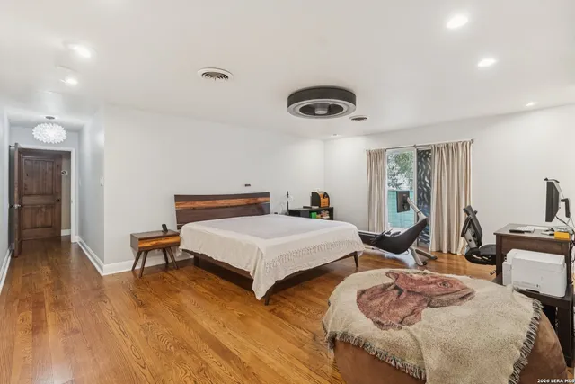 a bedroom with two beds and a large mirror next to a window
