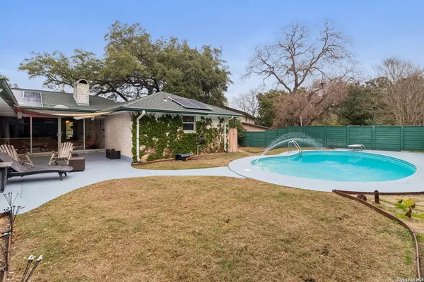 a view of a house with backyard and sitting area